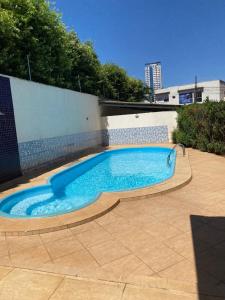 a swimming pool with a blue slide in a backyard at Flat muito bem localizado in Palmas