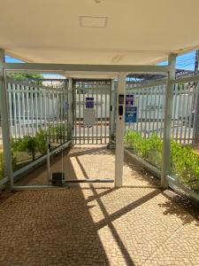 una puerta abierta en un edificio con una valla en Flat muito bem localizado, en Palmas
