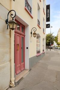 una puerta roja en el lateral de un edificio en Sonder Quintinie, en París