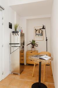 eine Küche mit einem Tisch und einem Kühlschrank in der Unterkunft Sonder Quintinie in Paris