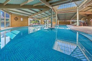 麥覺理港的住宿－ULTIQA Village Resort，大楼内一个蓝色瓷砖的大型游泳池
