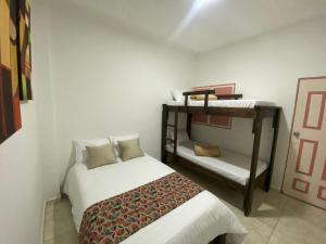 Mahalo Hostel في سالنتو: غرفة نوم مع سرير وسرير بطابقين