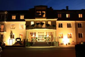 ein großes weißes Gebäude mit einer Treppe davor in der Unterkunft Hotel Alexa in Bad Mergentheim