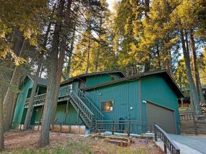 a green building with a staircase on the side of it at FirePit~Horseshoes~King Bed~Near Lake, Wine, Farms in Pollock Pines