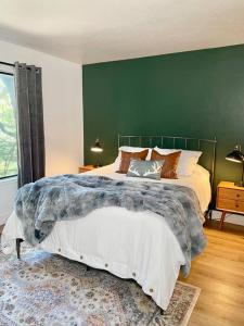 a bedroom with a large bed with a green wall at FirePit~Horseshoes~King Bed~Near Lake, Wine, Farms in Pollock Pines