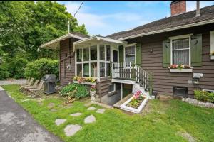 uma pequena casa com um alpendre e um quintal em Waldemar Charming Burlington lower level Apartment em Burlington