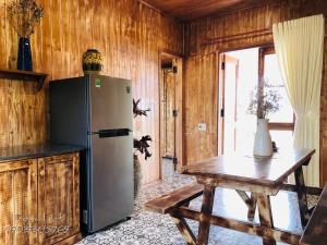 eine Küche mit einem Kühlschrank und einem Holztisch in der Unterkunft DuGiang Homestay in Buon Ma Thuot