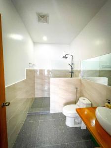 a bathroom with a toilet and a shower and a sink at Ocean View Guest House, Mabini in Batangas City