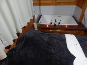 a bed in a room with a bath tub at Chalé Silvia Gatto - Suíte Bauru in Núcleo Mauá