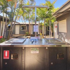 aptic tank in front of a house with palm trees at Econo Lodge Karratha in Karratha