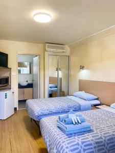 una camera d'albergo con due letti e asciugamani di Econo Lodge Karratha a Karratha