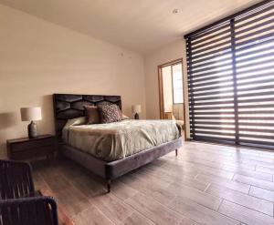 a bedroom with a large bed and a large window at Casa San Sebastián - San Miguel de Allende in San Miguel de Allende