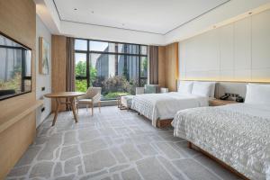 A bed or beds in a room at Le Méridien Emei Mountain Resort