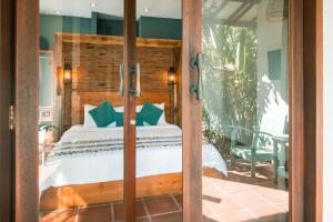 a bedroom with a bed and a glass door at Coconut Garden Resort in Gili Trawangan