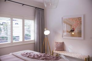 a bedroom with a bed and a lamp and a window at Sandringham in Daylesford