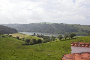 a view of a green field with a river in the distance at Hospedería Las Calzadas in San Vicente de la Barquera