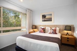 1 dormitorio con cama y ventana grande en #2 Hastings Street en Noosa Heads