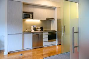 a kitchen with white cabinets and a microwave at Boulcott Suites in Wellington