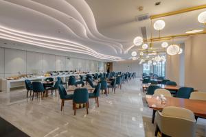 a dining room with chairs and tables and a ceiling with clouds at Huawen Four Season Hotel in Zhaoqing