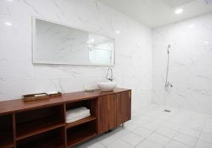 W łazience znajduje się umywalka i lustro. w obiekcie CF Pension w mieście Pohang