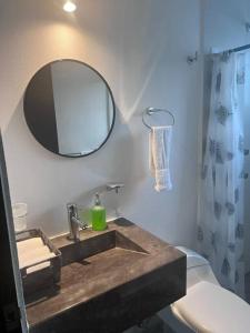 La salle de bains est pourvue d'un lavabo avec miroir et de toilettes. dans l'établissement Hermoso departamento en Acapulco, à Acapulco