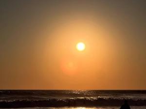 - une personne debout sur la plage pour observer le coucher du soleil dans l'établissement Hermoso departamento en Acapulco, à Acapulco