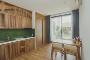 a kitchen with a table and chairs and a window at Animor Green Home Villa Da Nang in Da Nang