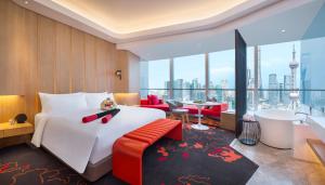 上海市にあるW 上海 ザ バンドの大きなベッドとバスルームが備わるホテルルームです。