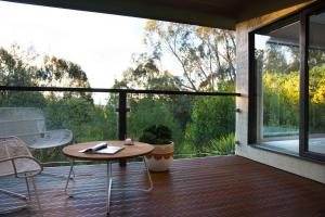 a patio with a table and chairs on a deck at Schafhalle in Hepburn Springs