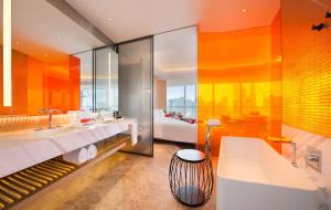 an orange bathroom with a tub and a sink at W Shanghai - The Bund in Shanghai