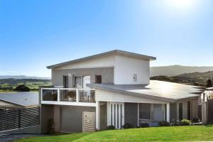 a large white house with a green lawn at Mountain Views (3 min drive to beach) in Gerringong