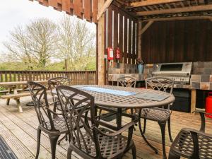 a patio with a table and chairs on a deck at Angarrack Farmhouse in Hayle