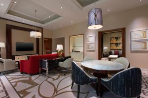 a living room with a table and a piano at Sheraton Grand Macao in Macau