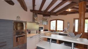 a large kitchen with wooden ceilings and a counter top at MAISON DE CARACTERE COSY in Sambin