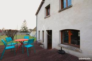 a patio with chairs and a table in front of a building at MAISON DE CARACTERE COSY in Sambin
