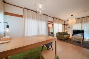 ein Wohnzimmer mit einem Holztisch und einem Sofa in der Unterkunft R-house 4th in Tokio