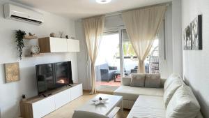 a living room with a white couch and a tv at Apartamento en Resort De Golf in Torre-Pacheco