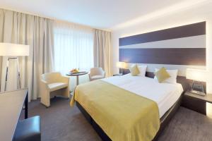 una camera d'albergo con un letto grande e un tavolo di Parc Hotel Alvisse a Lussemburgo