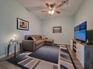 uma sala de estar com um sofá e uma televisão de ecrã plano em Greenlinks 923 at Lely Resort - Luxury 2 Bedrooms & Den Condo em Naples