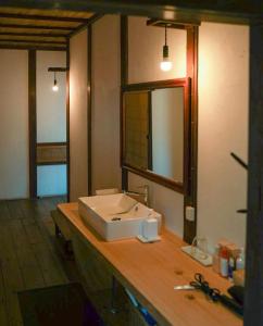 a bathroom with a sink and a mirror on a counter at entohouse BAR&GUESTHOUSE 