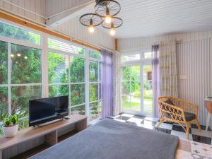 - une chambre avec une télévision, un canapé et des fenêtres dans l'établissement La Cle' Đà Lạt, à Đà Lạt