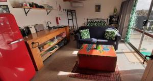 een woonkamer met een stoel en een tafel bij The Poolhouse in Matamata