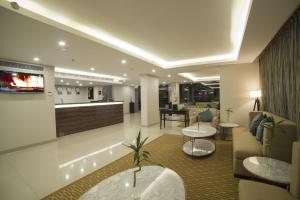 a hotel lobby with two tables and a bar at Tulip Inn - Taskeen Served Apartment in Dammam