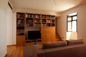 a living room with a couch and a tv and book shelf at Casa Da Quinta De Vale D' Arados in Mesão Frio