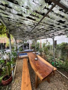 a wooden table sitting under a roof in a garden at Asahi Luxstay - Homestay Đường Lâm Hostel in Sơn Tây