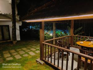 a porch of a house with a table and chairs at Getaway Beach Resort Kovalam in Kovalam