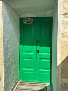 una puerta verde en una esquina de un edificio en Venezia in Abruzzo, en Archi