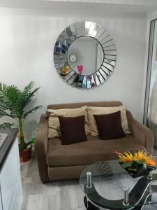 a living room with a couch and a mirror at Azure Residences by Van Florendo in Manila