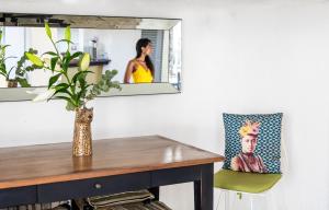 a dining room table with a vase and a chair at Guest House et Restaurant Sous le Badamier in Grand-Baie