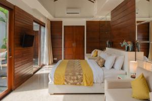 a bedroom with a large bed and a couch at Anari Villas Kuta in Legian